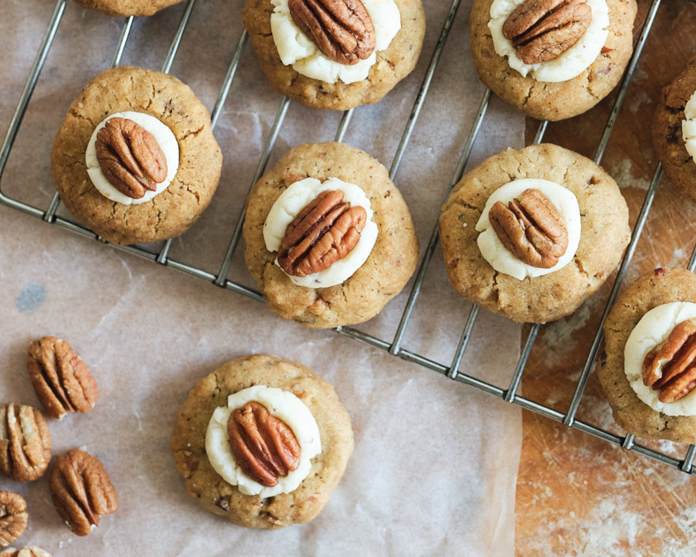 Browned Butter Pecan Thumbprint Cookies on wire cooling rack with parchment paper underneath