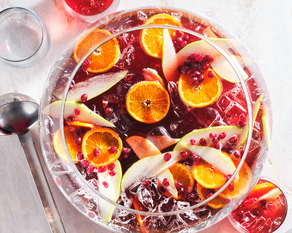 Punch bowl filled with Sparkling Pomegranate Wine Punch and fruit slices