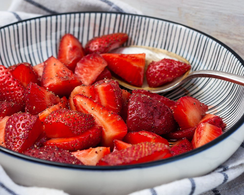 Balsamic macerated strawberries in a bowl with a spoon