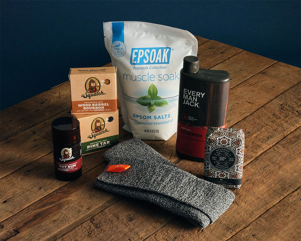 Image of epsom salt, socks, and soap on a wood table.