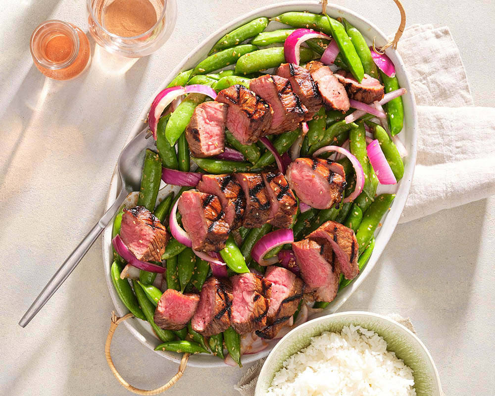 Kalbi Marinated Tri Tip with Asian Snap Peas on White Platter