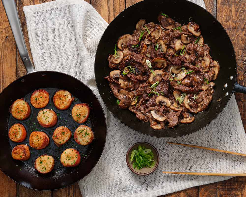 Two pans with scallops and beef entrees