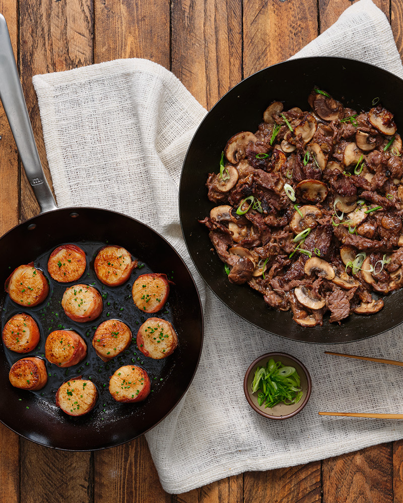 Two pans with scallops and beef entrees