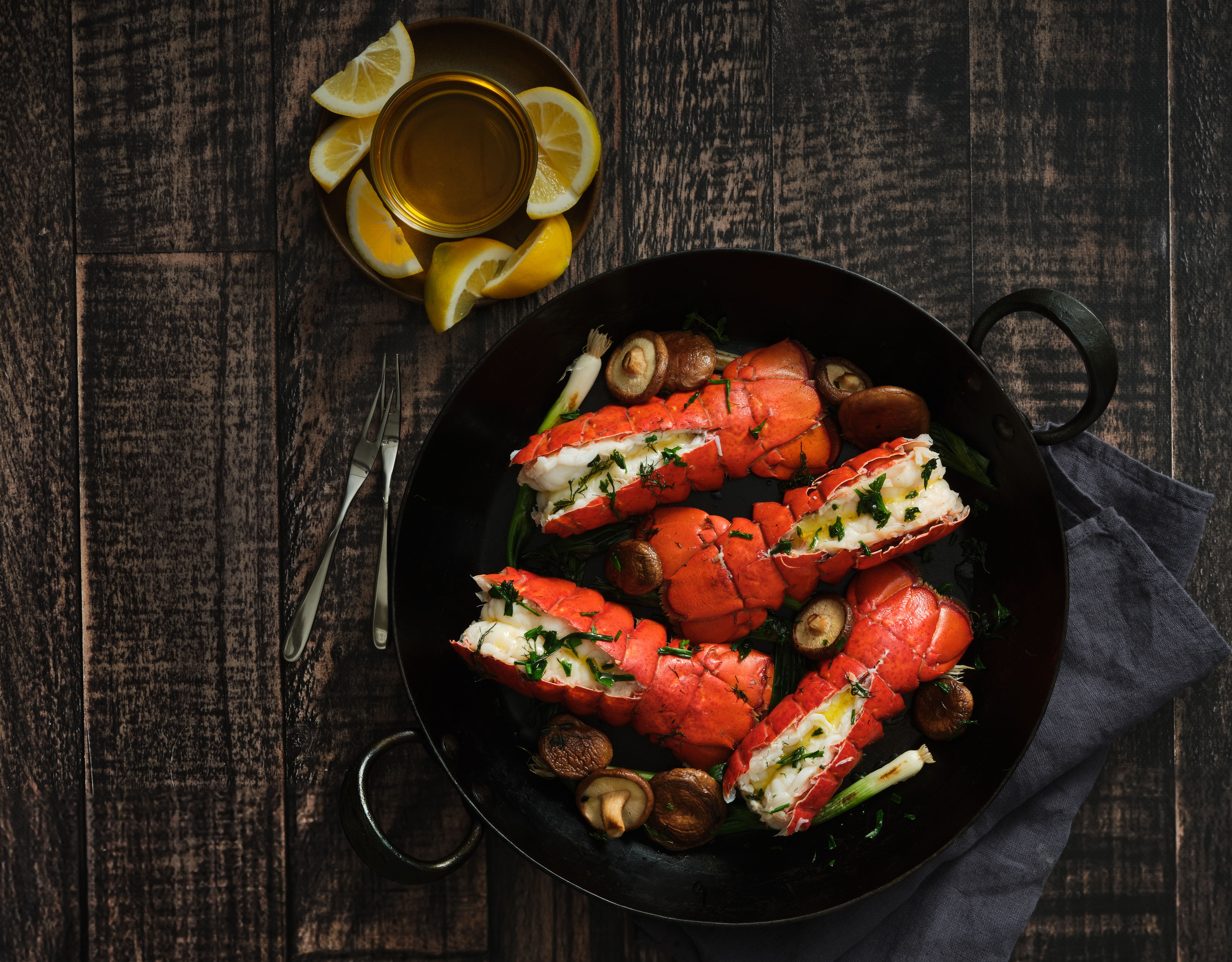 Cooked lobster in cast iron pan with lemons