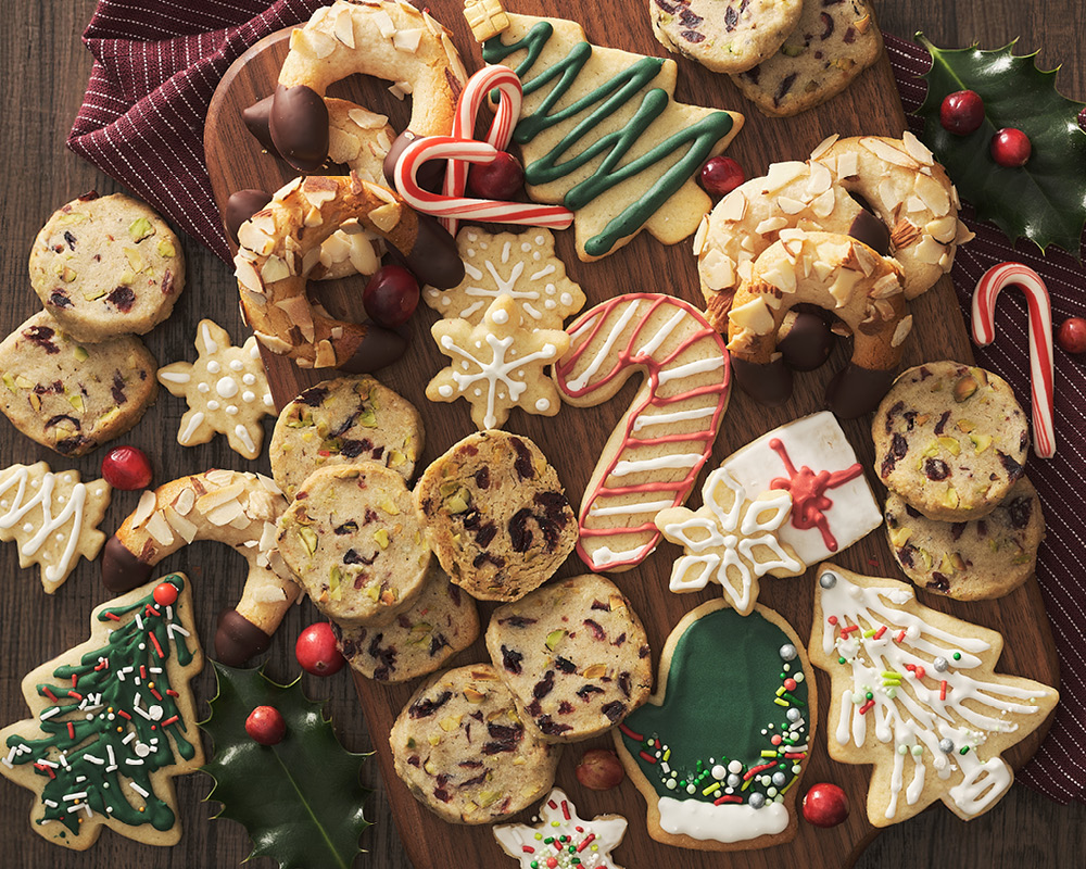 An assortment of holiday cookies on a wooden serving platter